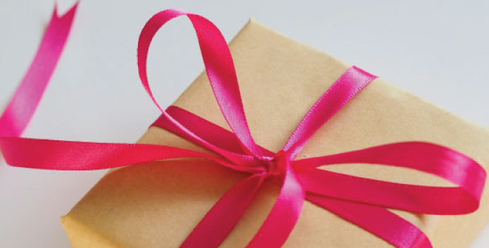 Present wrapped in gold gift paper and bright red satin bow
