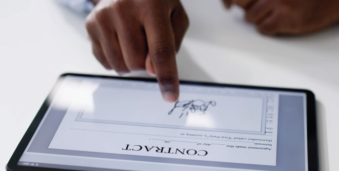 Cyber security - person signing a legal contract electronically on a tablet