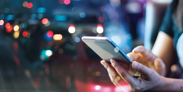 A person using their mobile in public to show public wifi dangers