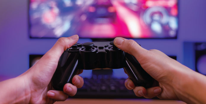 Hands holding a gaming PC controller in front of a screen