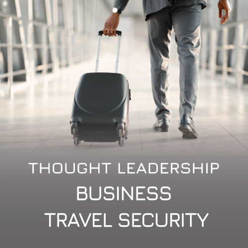 Businessman in a suit wheeling along a suitcase