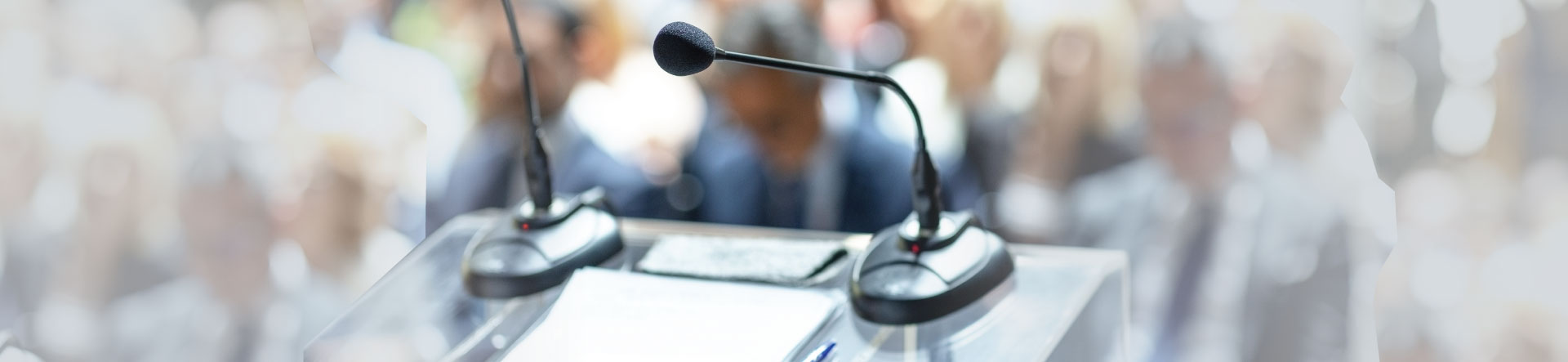 A podium with microphones looking out to the conference floor where delegates are sitting