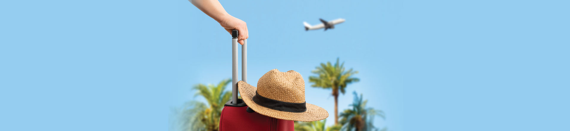 Suitcase with a straw hat resting on top with palm trees and a holiday jet taking off in a clear blue sky - travel tech for holidays